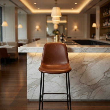 Brown leather bar stool with curved seat and back, black metal frame and footrest