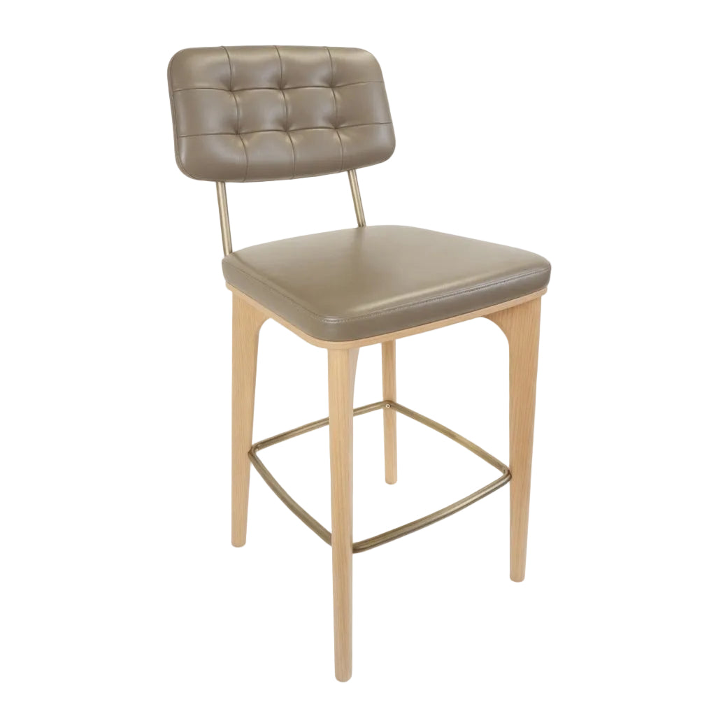 Upholstered bar stool with tufted back and beige seat, light wood legs and gold footrest.
