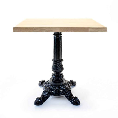 wooden table top with a decorative thick black metal base on a white background