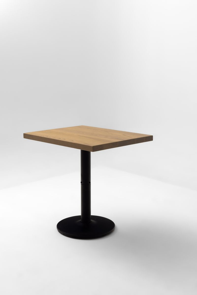 Square ash table top on black pedestal base, natural wood grain finish
