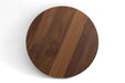 Round walnut table top with visible wood grain in a dark-brown finish.